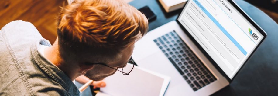 Focused caucasian man college student in glasses studying with b