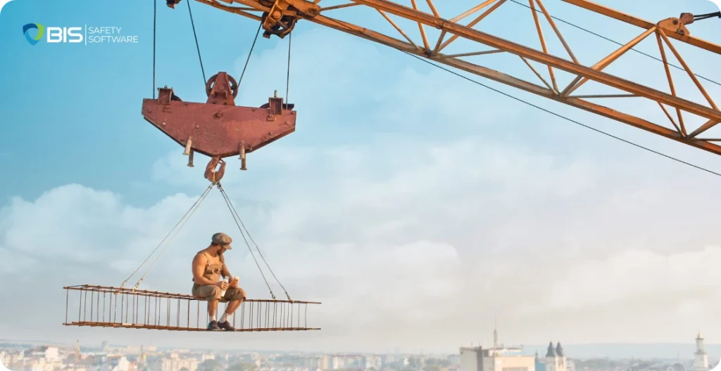 Construction worker dangerously suspended on a crane platform without safety gear.