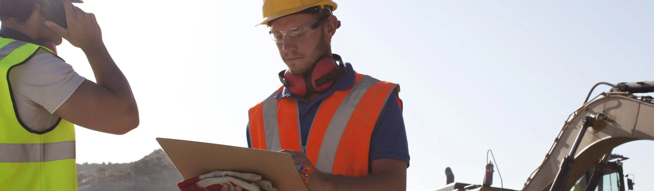 worker using LMS on tablet for safety inspection at an industrial facility staircase.